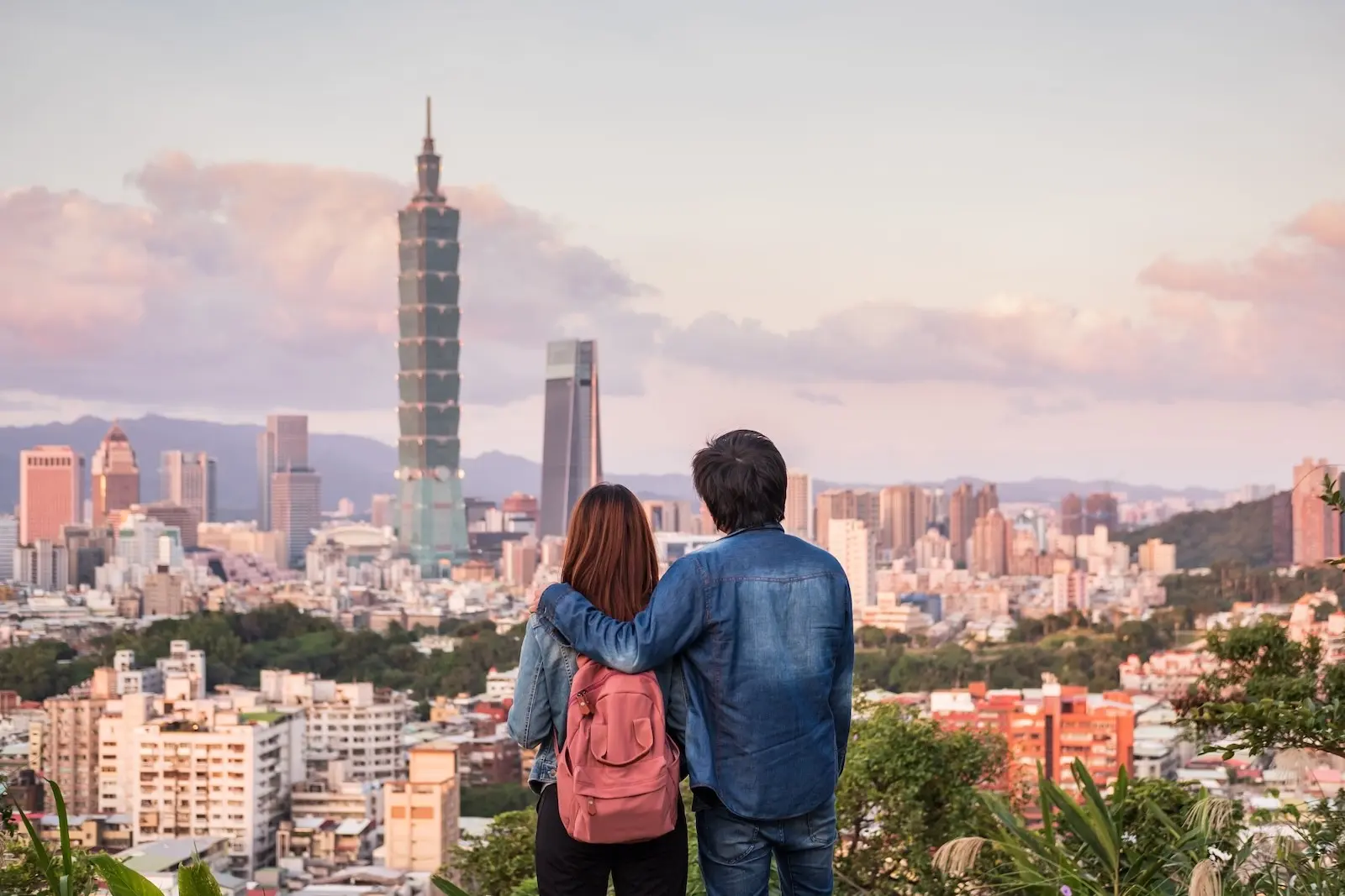 Đôi vợ chồng ngắm đường chân trời Taipei 101 từ đỉnh đồi vào lúc hoàng hôn
